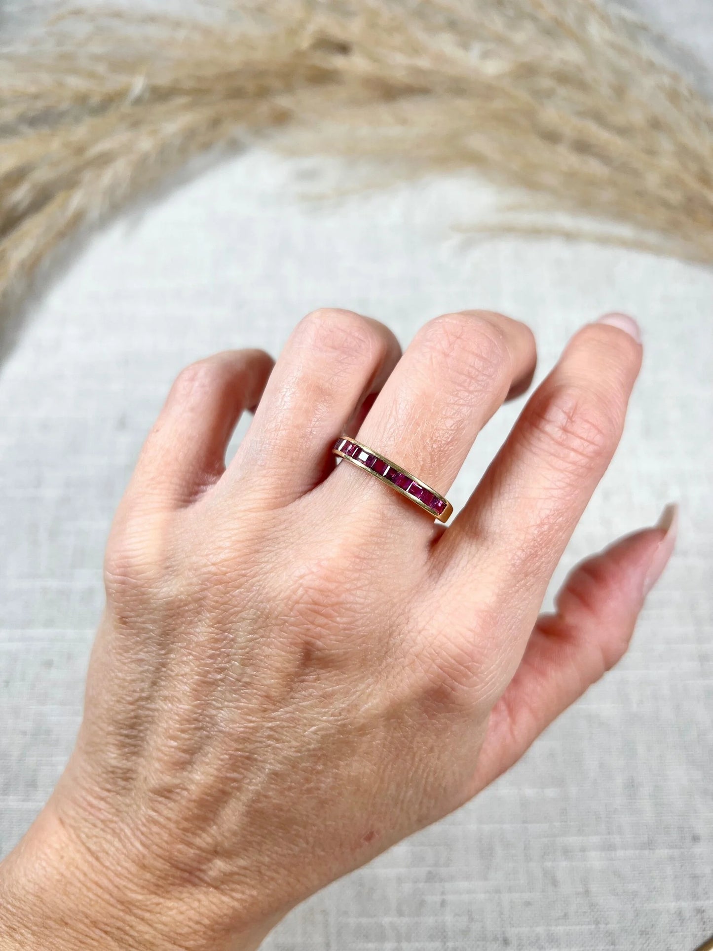 A yellow gold ruby channel set eternity band, modelled on a hand