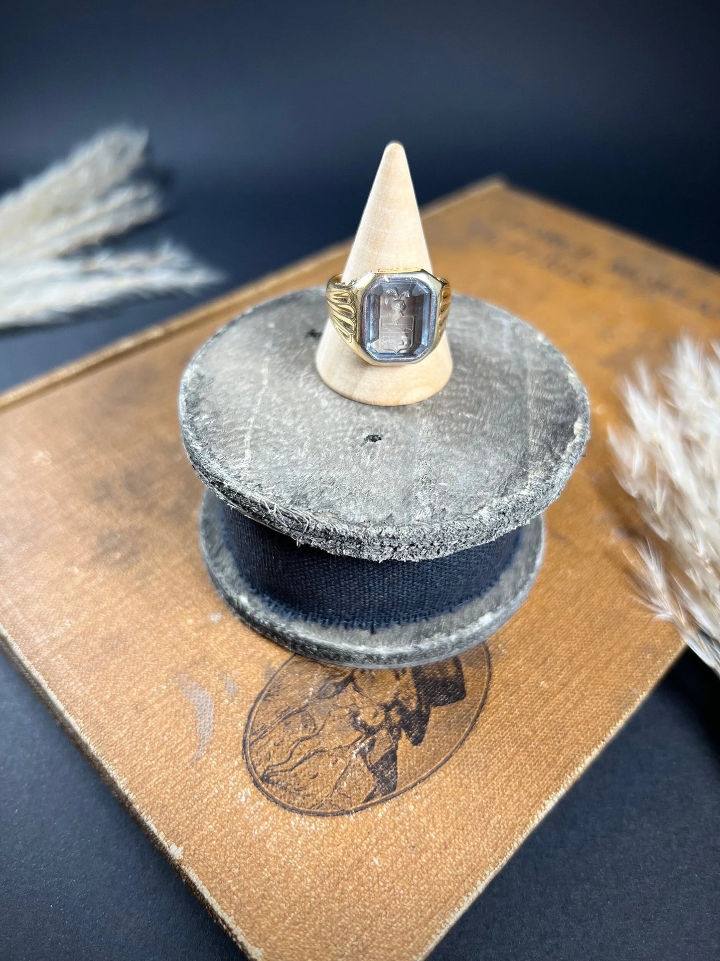 A yellow gold blue glass intaglio signet ring, on a ring cone