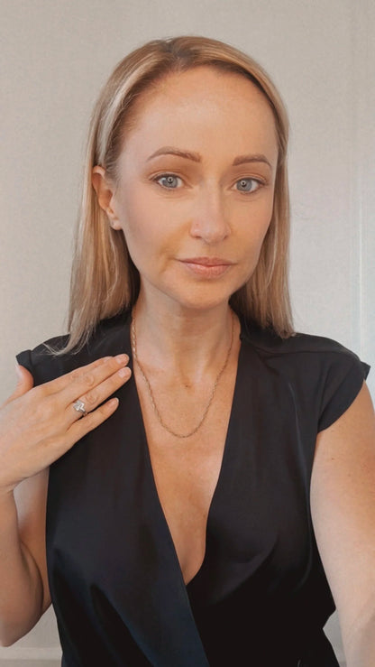 A gold paperclip link chain necklace, modelled by a woman