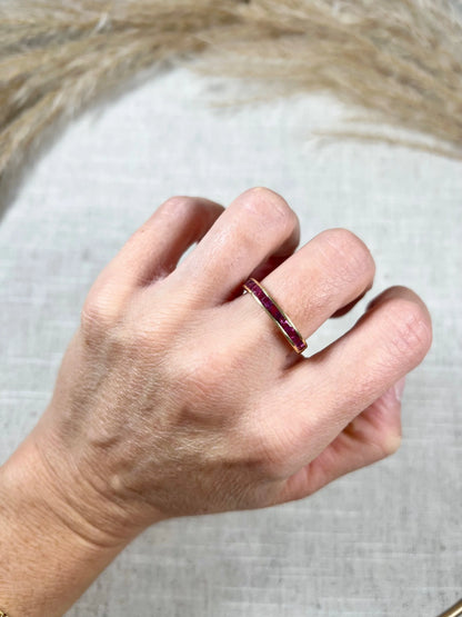 A yellow gold ruby channel set eternity band, modelled on a hand