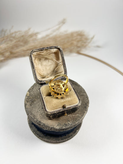 A black onyx and seed pearl fancy halo cluster ring in yellow gold, in a ring box