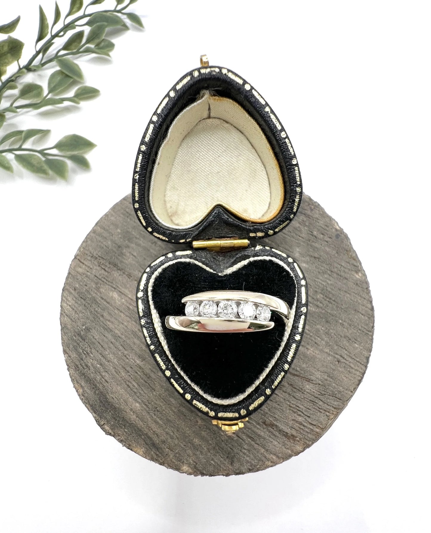 A five stone brilliant cut diamond ring in white gold, in a heart-shaped ring box