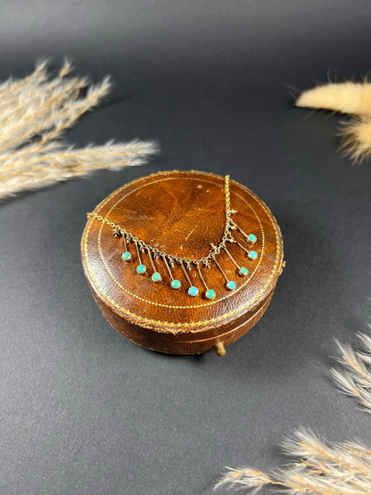 A gold negligee pendant necklace with turquoise drops