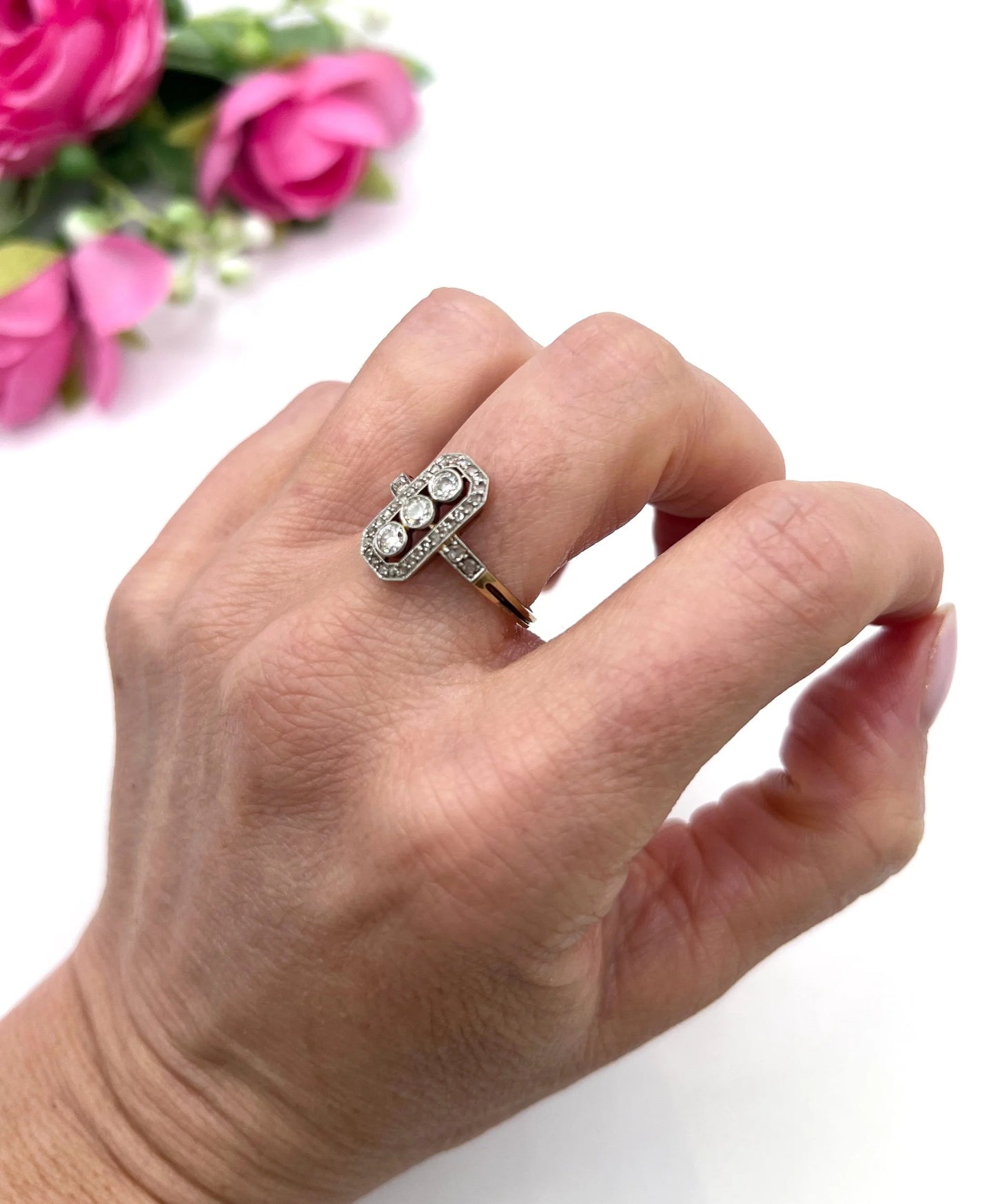 A diamond open cluster ring with three principal diamonds, in yellow and white gold, modelled on a hand