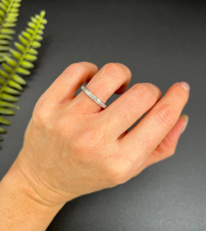 A diamond full eternity ring in white gold, modelled on a hand