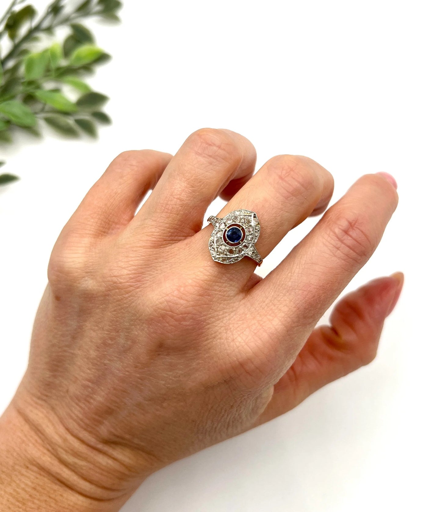 A sapphire and diamond openwork ring in platinum with a yellow gold ring shank, modelled on a hand