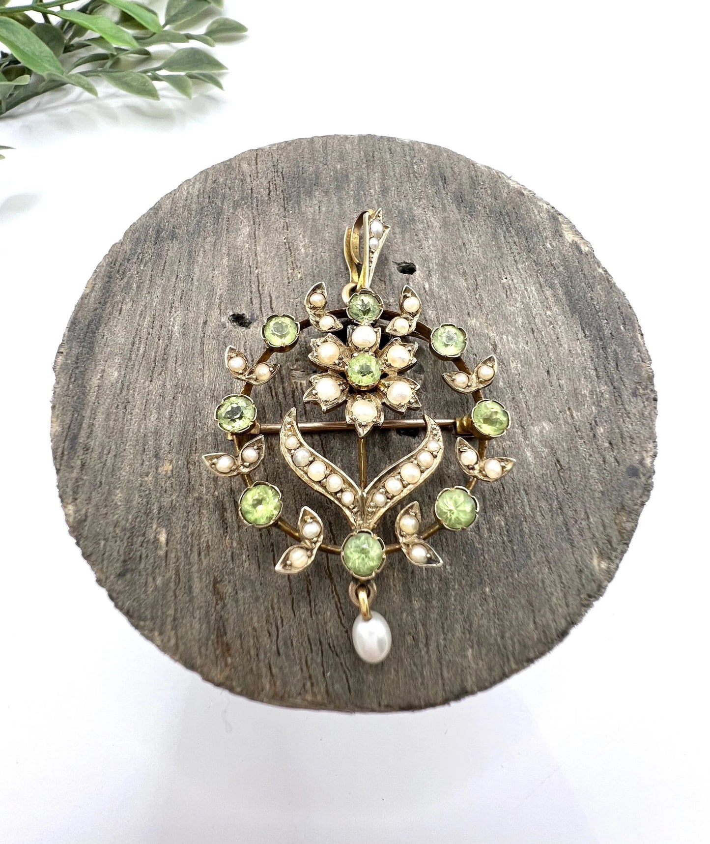 A peridot and pearl floral circle brooch/pendant in yellow gold