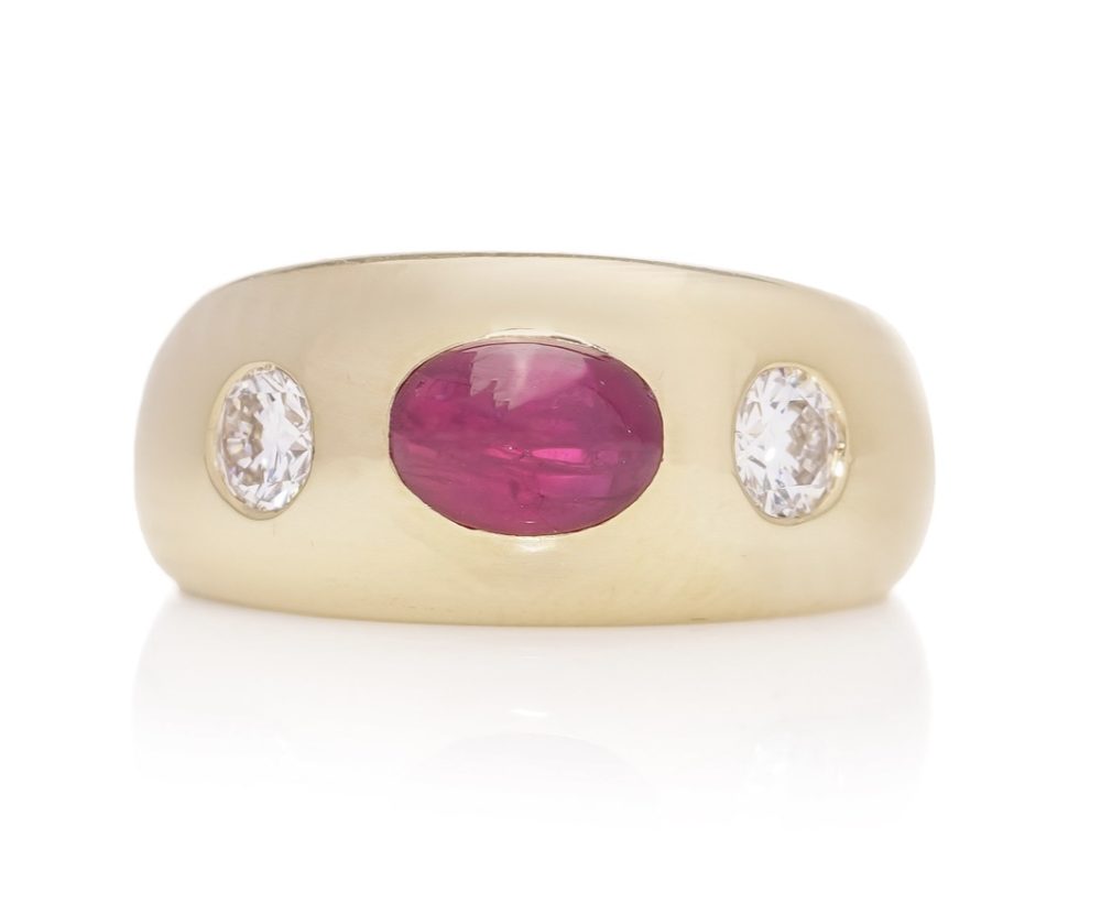 Bulgari 18ct. yellow gold gypsy set three stone ring, set with oval 1.29 cts. of Natural Burma cabochon ruby and 0.40 cts. of round Old-European cut diamonds.
