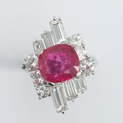 A vintage ruby and diamond cluster ring with cushion cut certified Burmese ruby surrounded by baguette- and diamond -cut ballerina cluster.