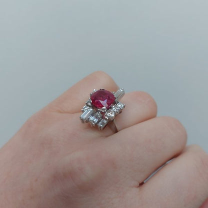 A vintage ruby and diamond cluster ring with cushion cut certified Burmese ruby surrounded by baguette- and diamond -cut ballerina cluster.