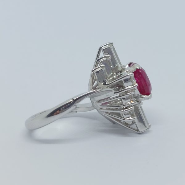 A vintage ruby and diamond cluster ring with cushion cut certified Burmese ruby surrounded by baguette- and diamond -cut ballerina cluster.