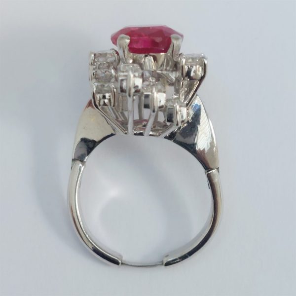 A vintage ruby and diamond cluster ring with cushion cut certified Burmese ruby surrounded by baguette- and diamond -cut ballerina cluster.