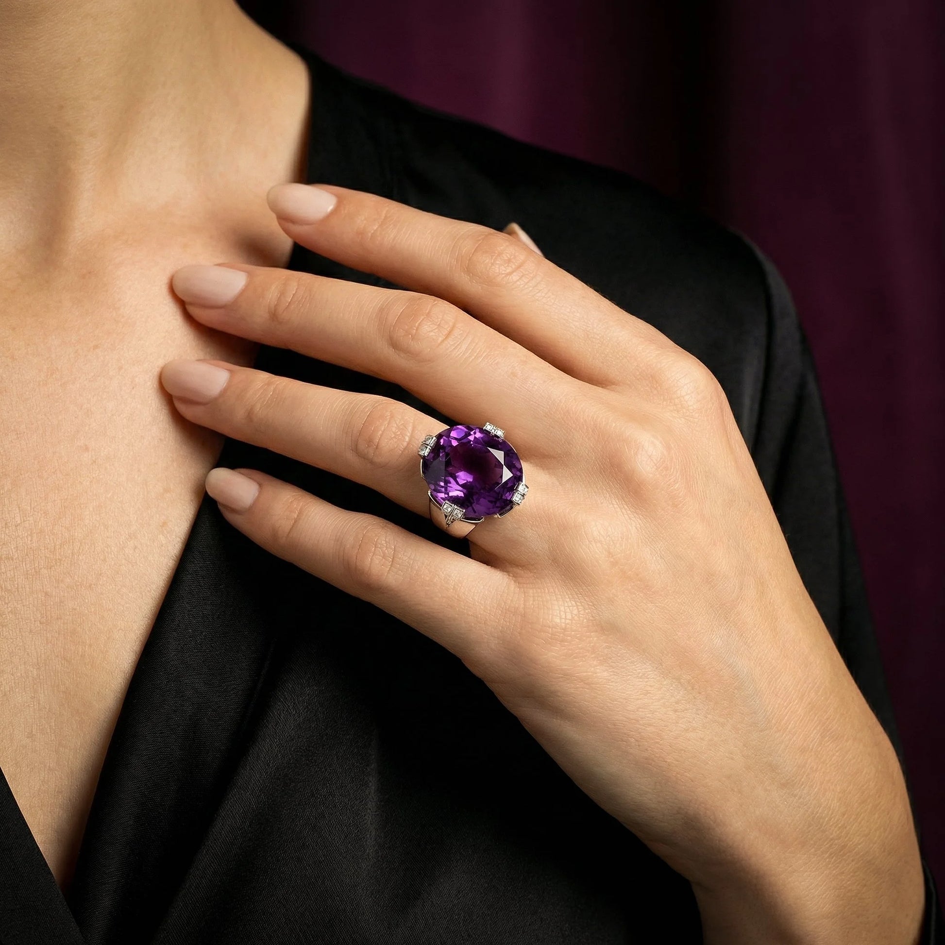 A round amethyst and diamond cocktail ring in white gold, modelled on a hand