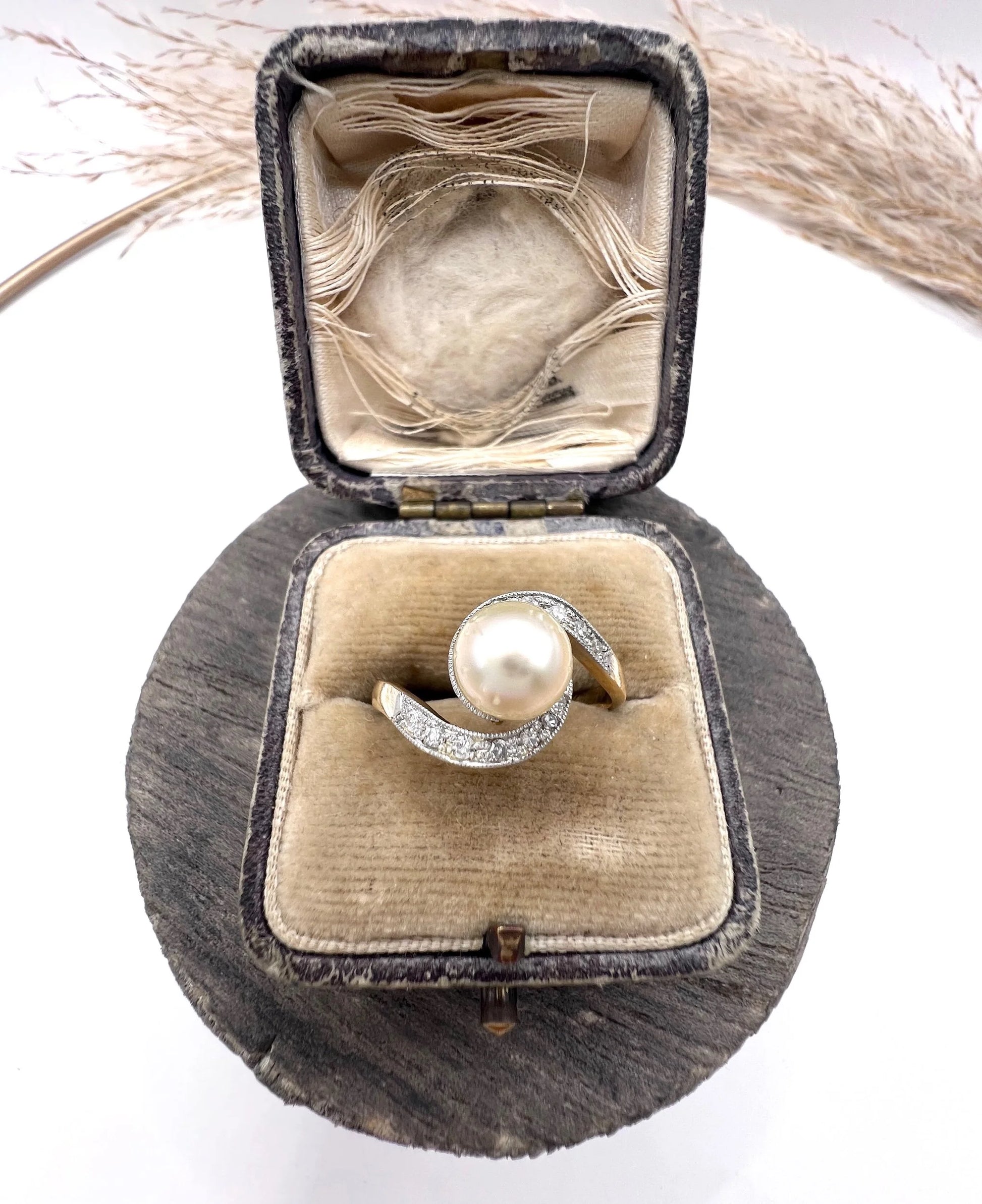 A pearl and diamond crossover swirl ring in yellow and white gold, in an antique box