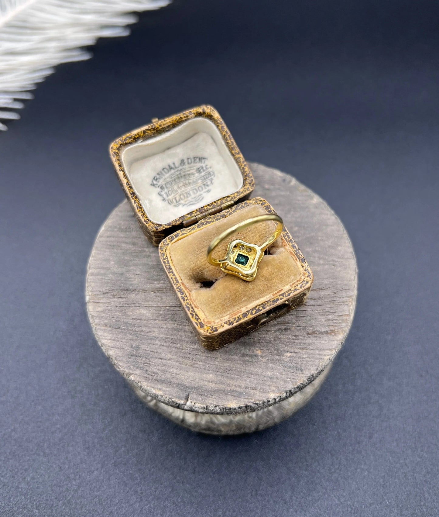 An emerald and diamond cluster ring in yellow gold and platinum, in an antique ring box