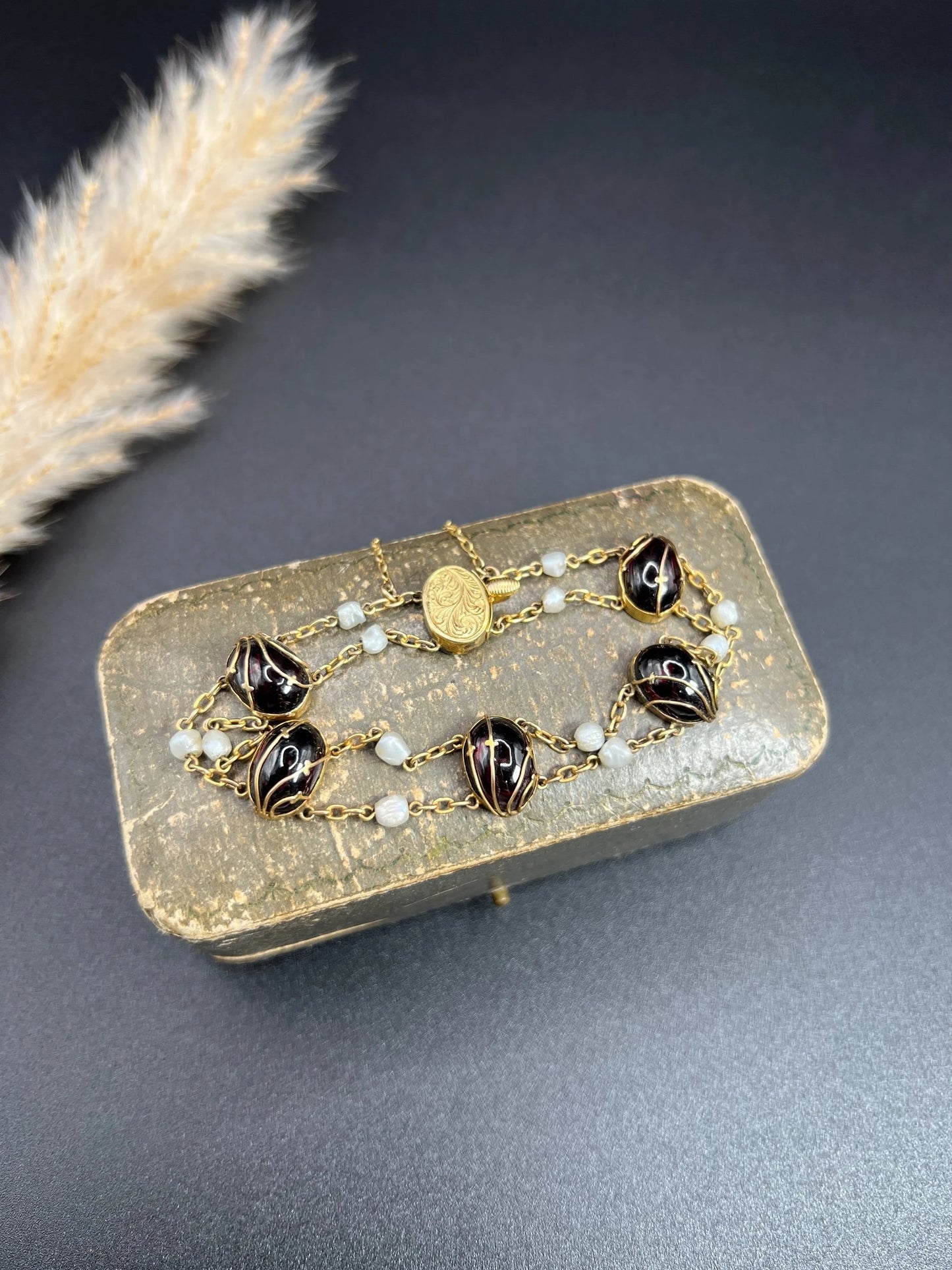 A yellow gold bracelet with oval cabochon garnets and white pearls