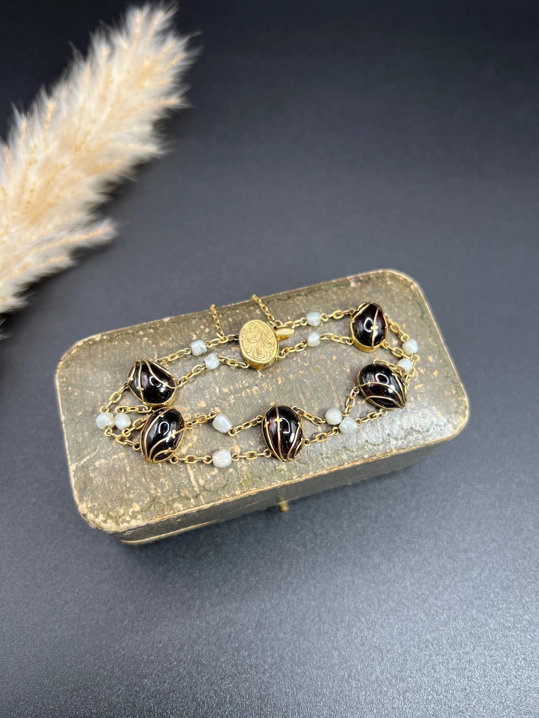 A yellow gold bracelet with oval cabochon garnets and white pearls