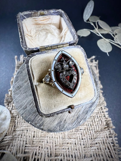 An ornate diamond and enamel navette shaped antique ring, in an antique ring box