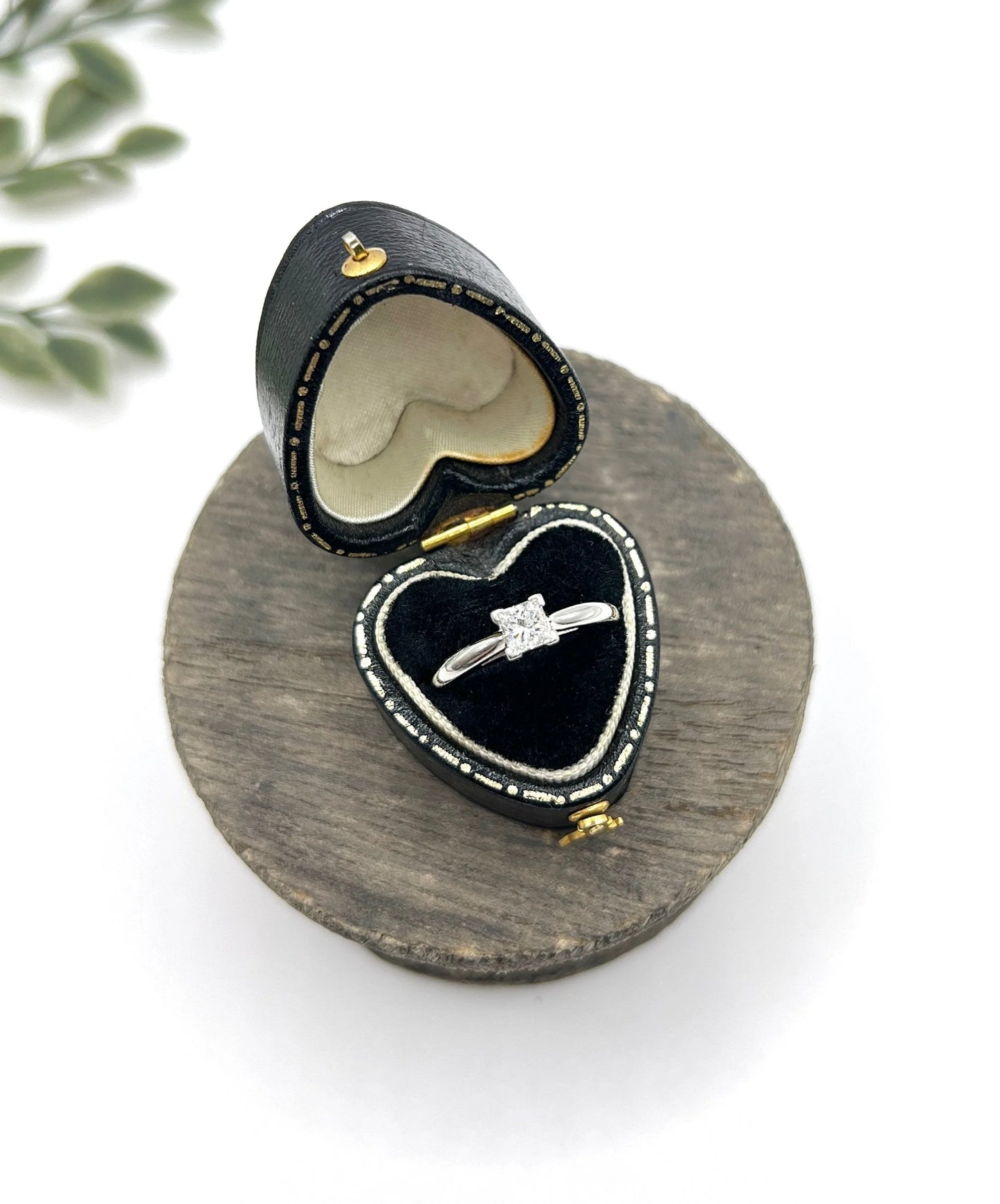 A princess cut diamond solitaire ring in platinum, in a heart-shaped ring box
