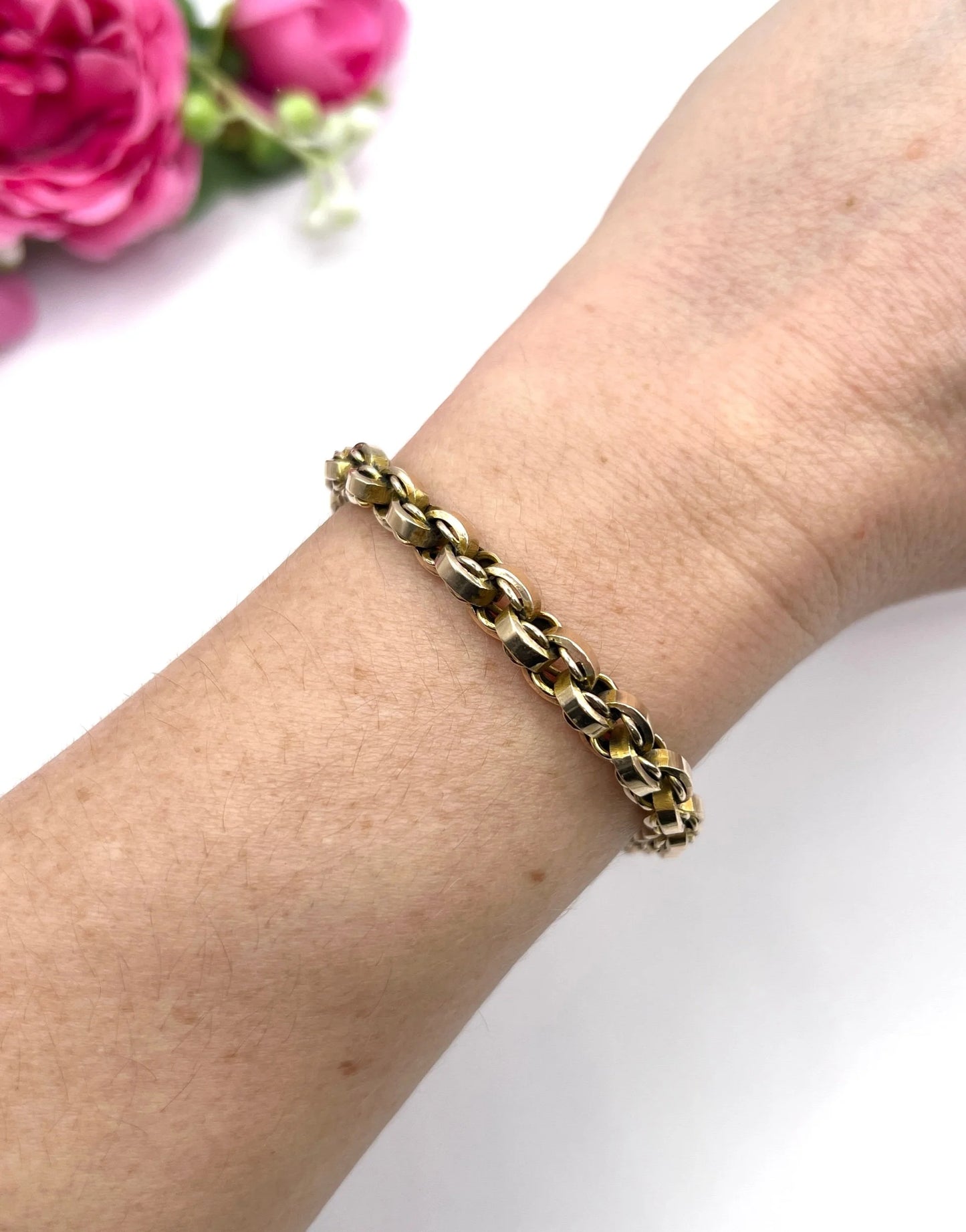 A gold round link bracelet, modelled on a wrist