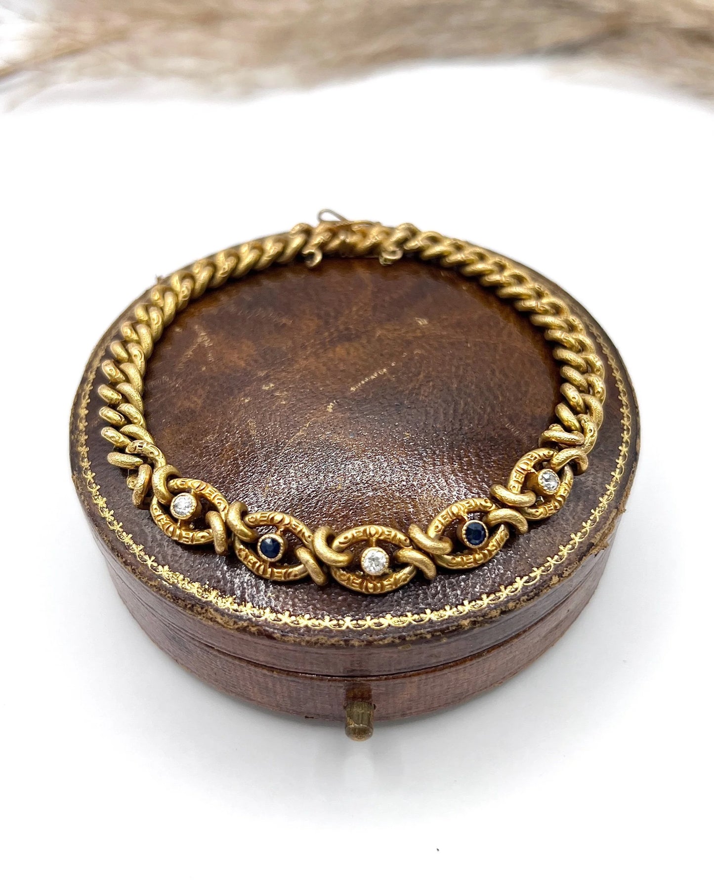 A sapphire and diamond fancy curb link bracelet in yellow gold