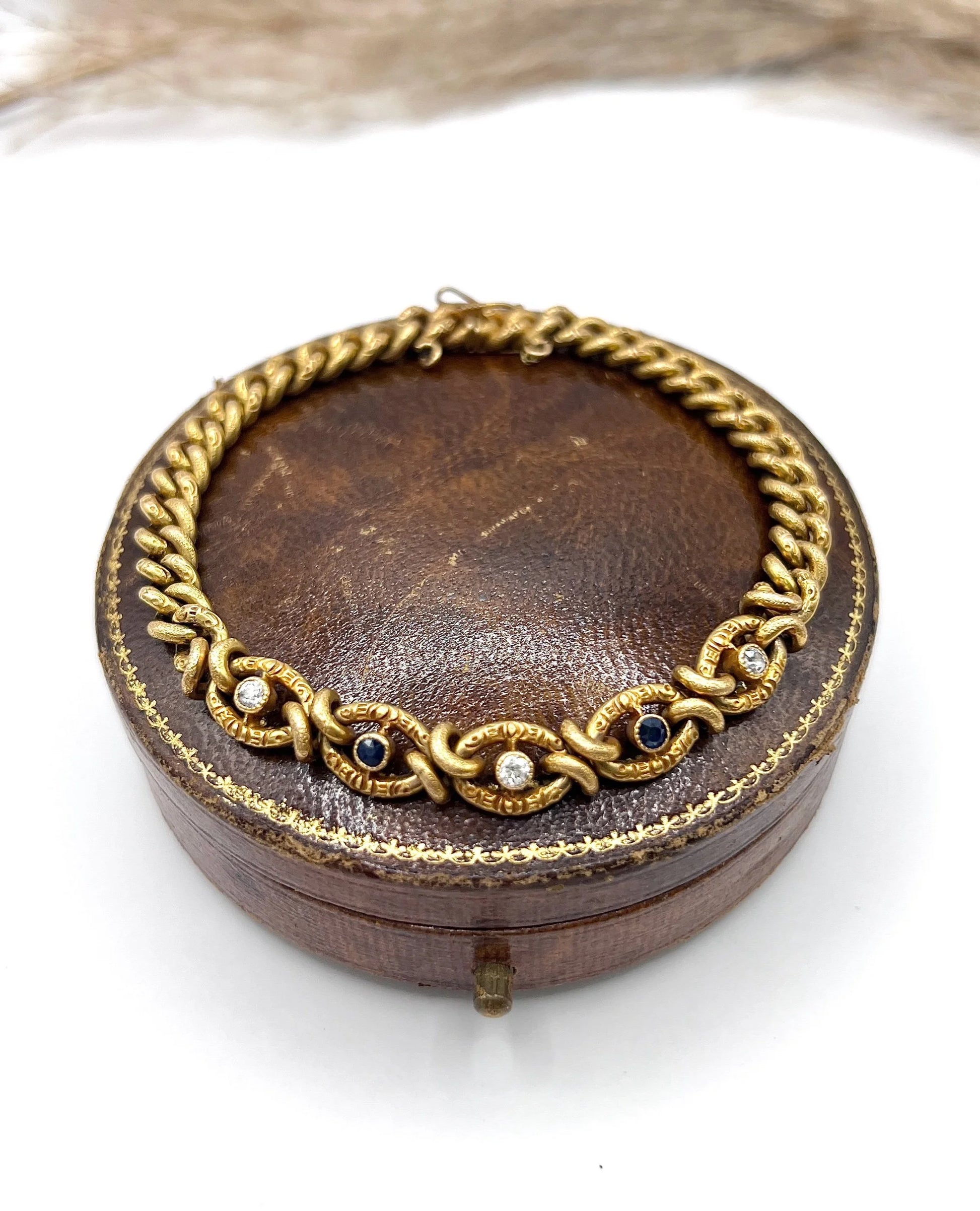 A sapphire and diamond fancy curb link bracelet in yellow gold