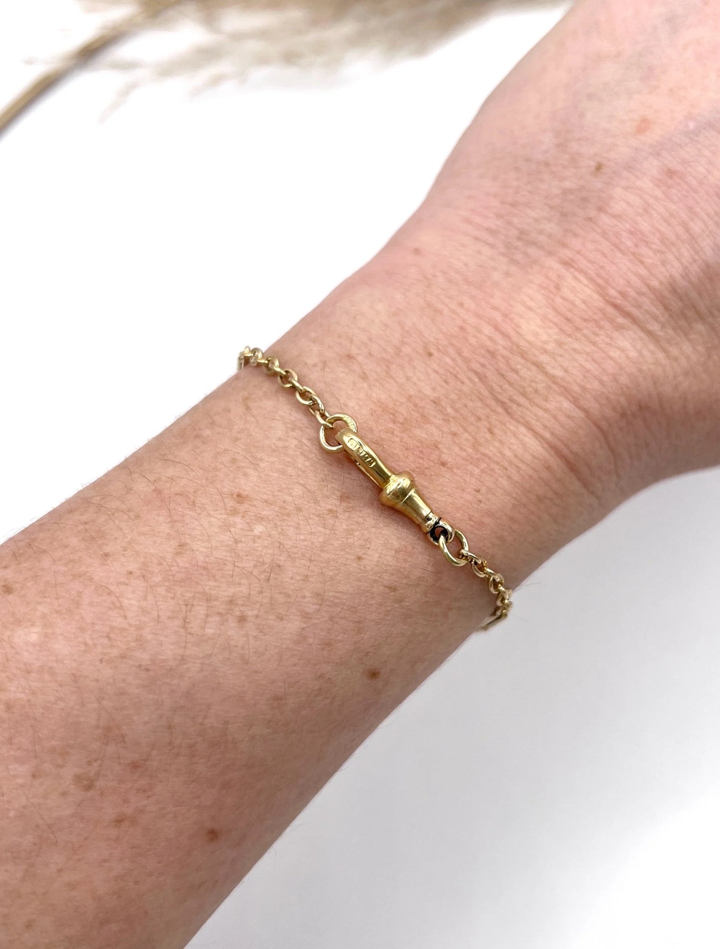 A yellow gold link bracelet with a lobster claw clasp, modelled on a wrist