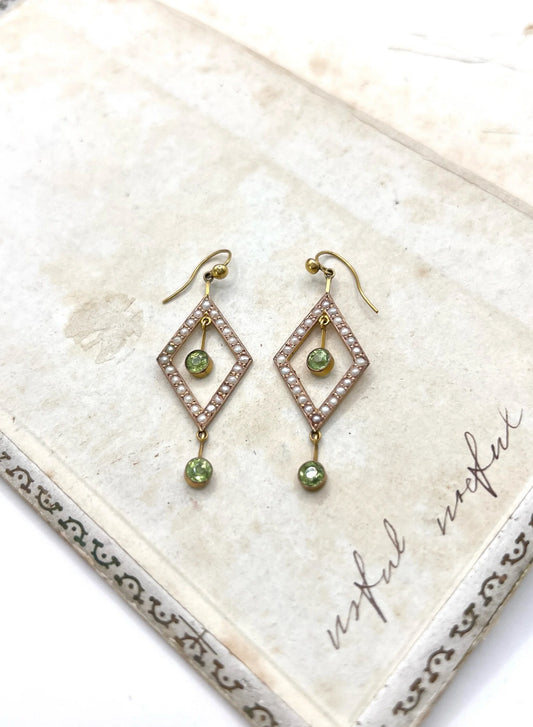 A pair of open diamond shaped drop earrings with peridots and pearls in yellow gold