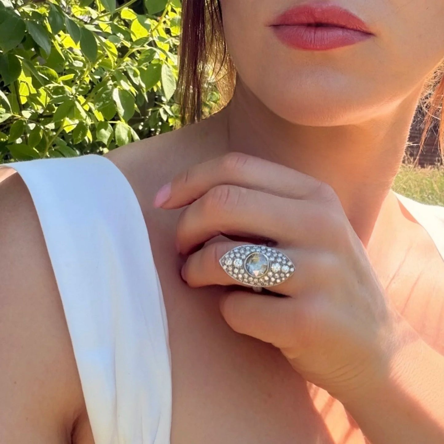 A marquise shaped diamond cluster ring with a central rose cut diamond, in white gold, modelled on a hand