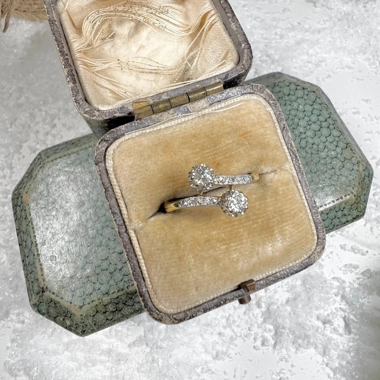 A two stone diamond crossover ring in yellow and white gold, in a ring box