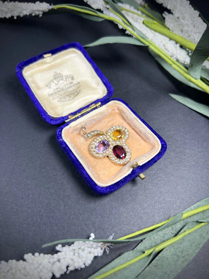 A yellow gold clover pendant with amethyst, citrine, garnet and seed pearls, in an antique box