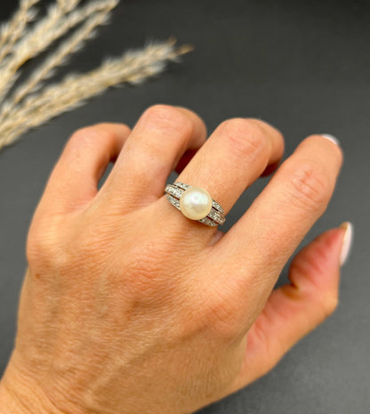 A pearl and diamond ring in platinum, modelled on a hand