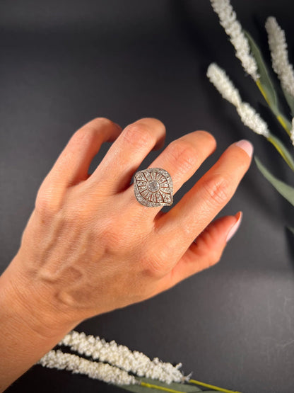 A diamond cocktail ring in yellow and white metal modelled on a hand
