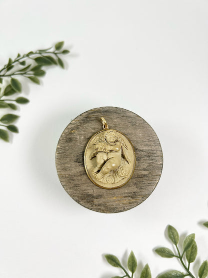 An oval cherub lava cameo pendant in yellow gold