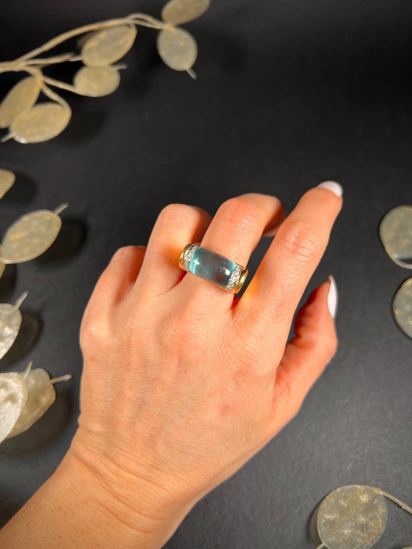 A blue topaz and diamond ring in yellow gold, modelled on a hand
