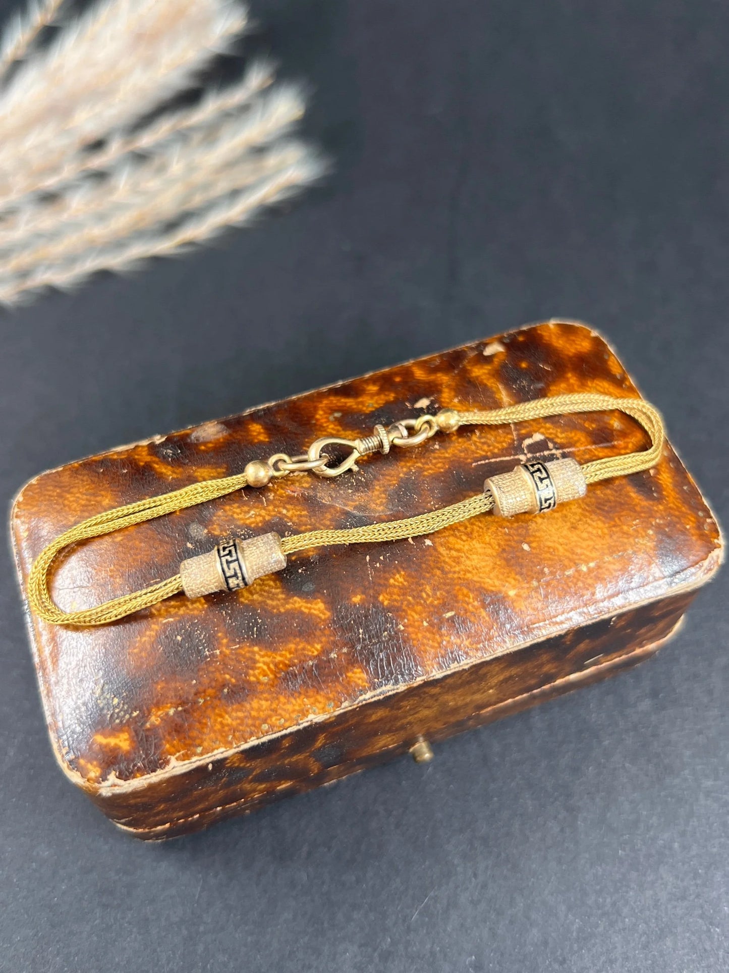 A yellow gold double row bracelet with black enamel tubular beads