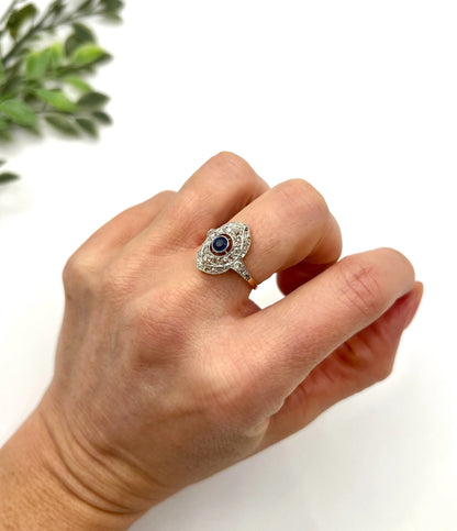 A sapphire and diamond openwork ring in platinum with a yellow gold ring shank, modelled on a hand