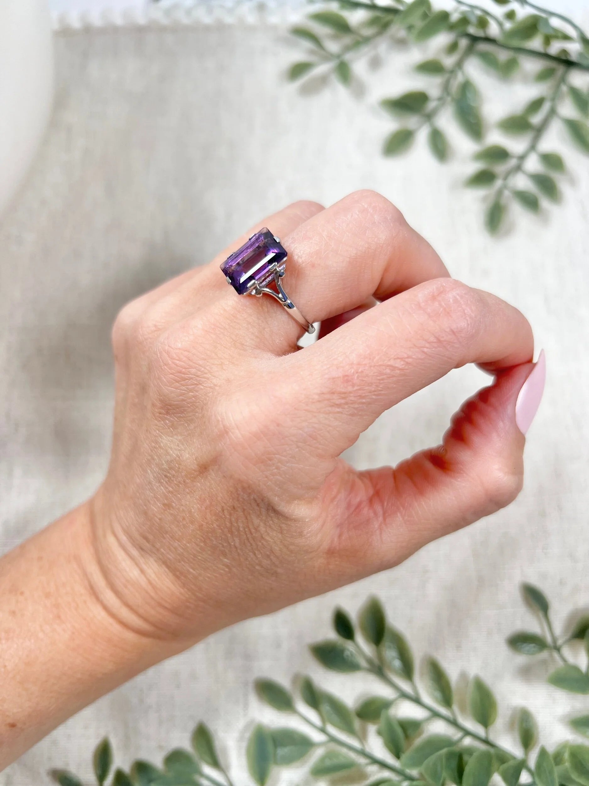 A solitaire amethyst cocktail ring in platinum, modelled on a hand