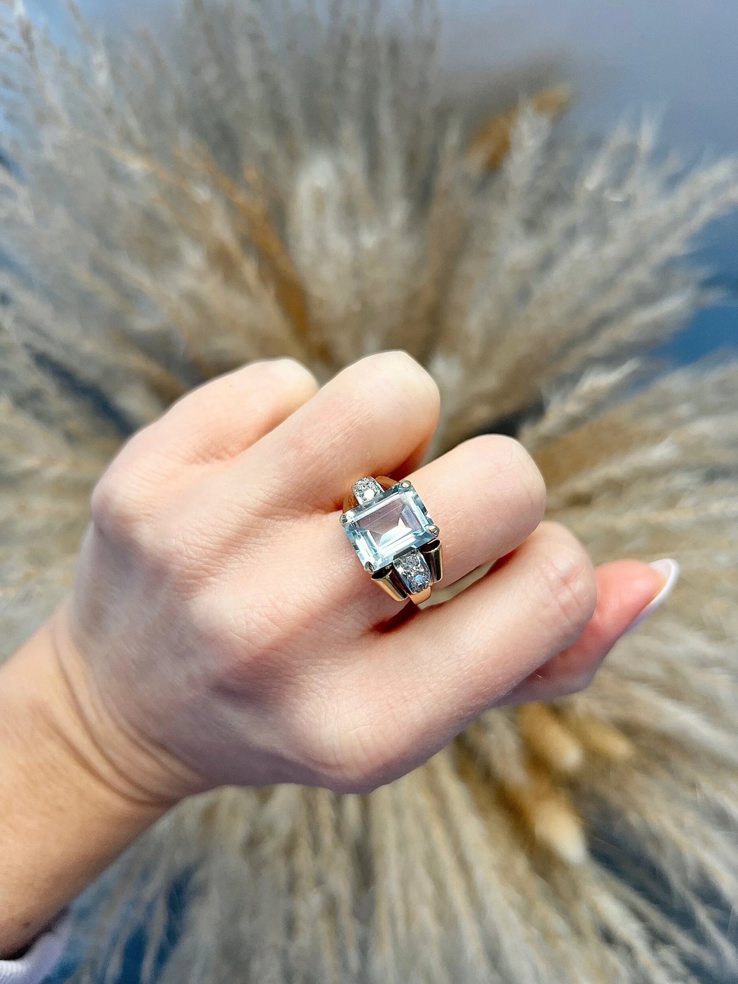 An aquamarine and diamond cocktail ring in gold, modelled on a hand