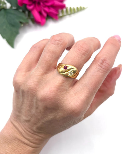 A yellow gold double headed snake ring with a ruby and a diamond, modelled on a hand