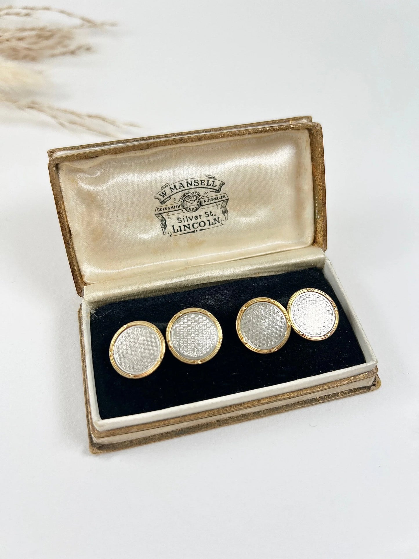 A pair of circular platinum and yellow gold cufflinks, in an antique box