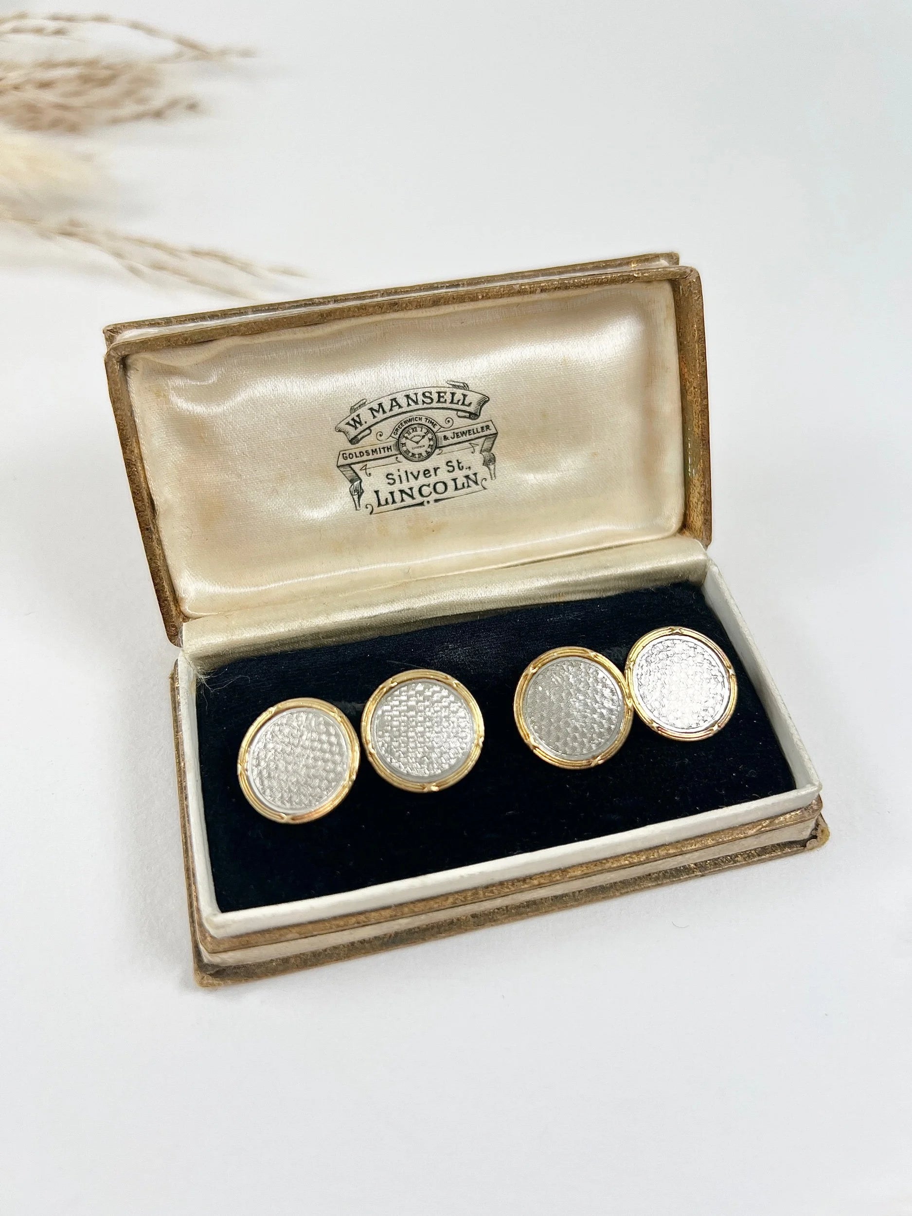A pair of circular platinum and yellow gold cufflinks, in an antique box