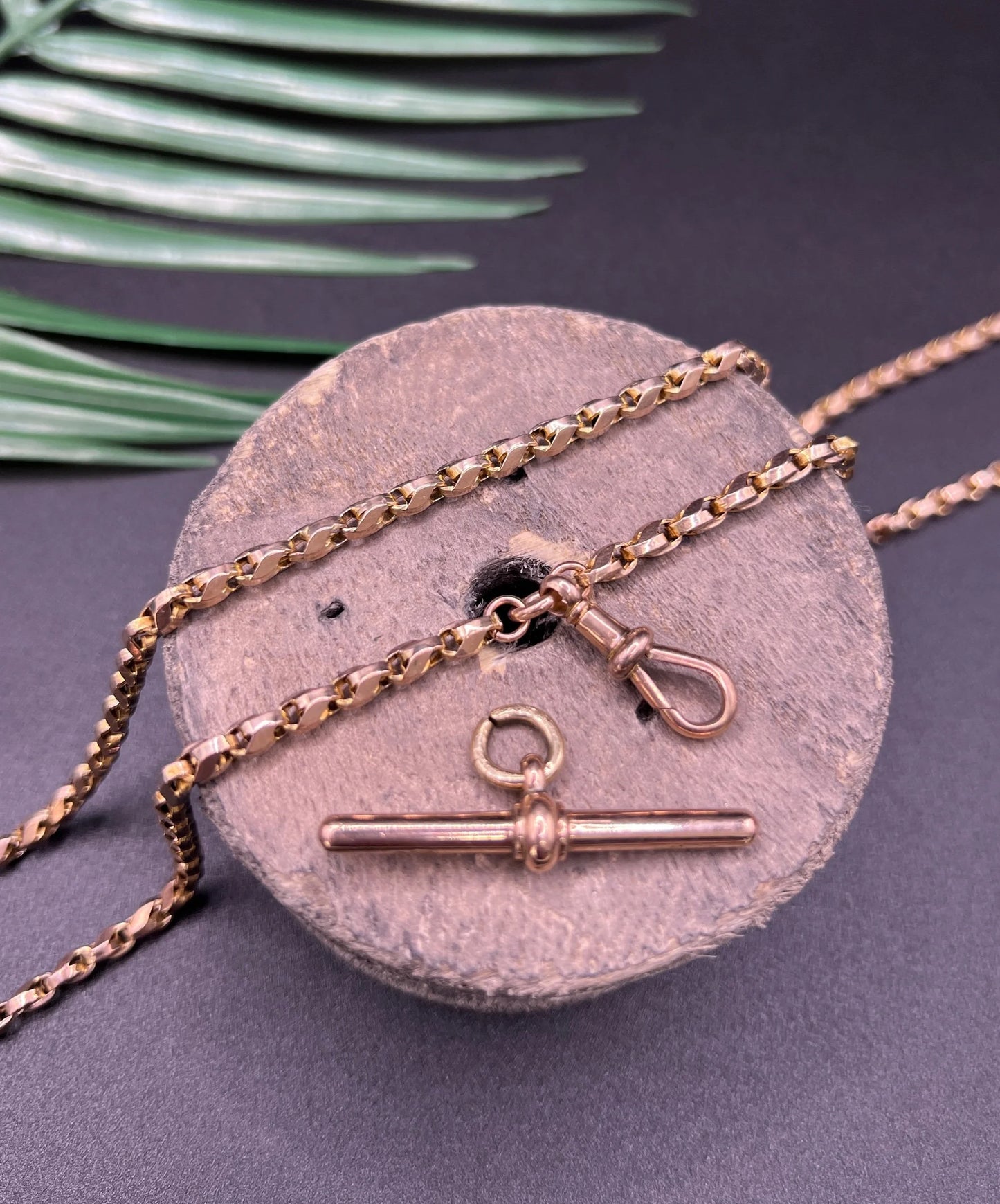 A rose gold tulip link chain necklace with a dog clip clasp and T-bar