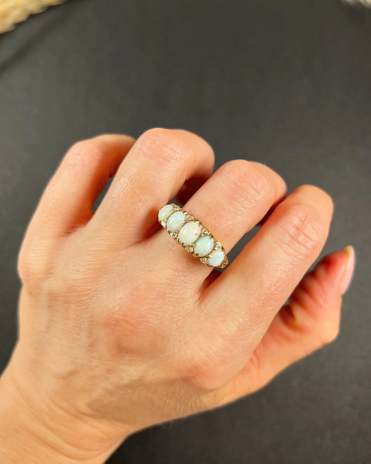 A cabochon opal and diamond carved half hoop ring in yellow gold, modelled on a hand