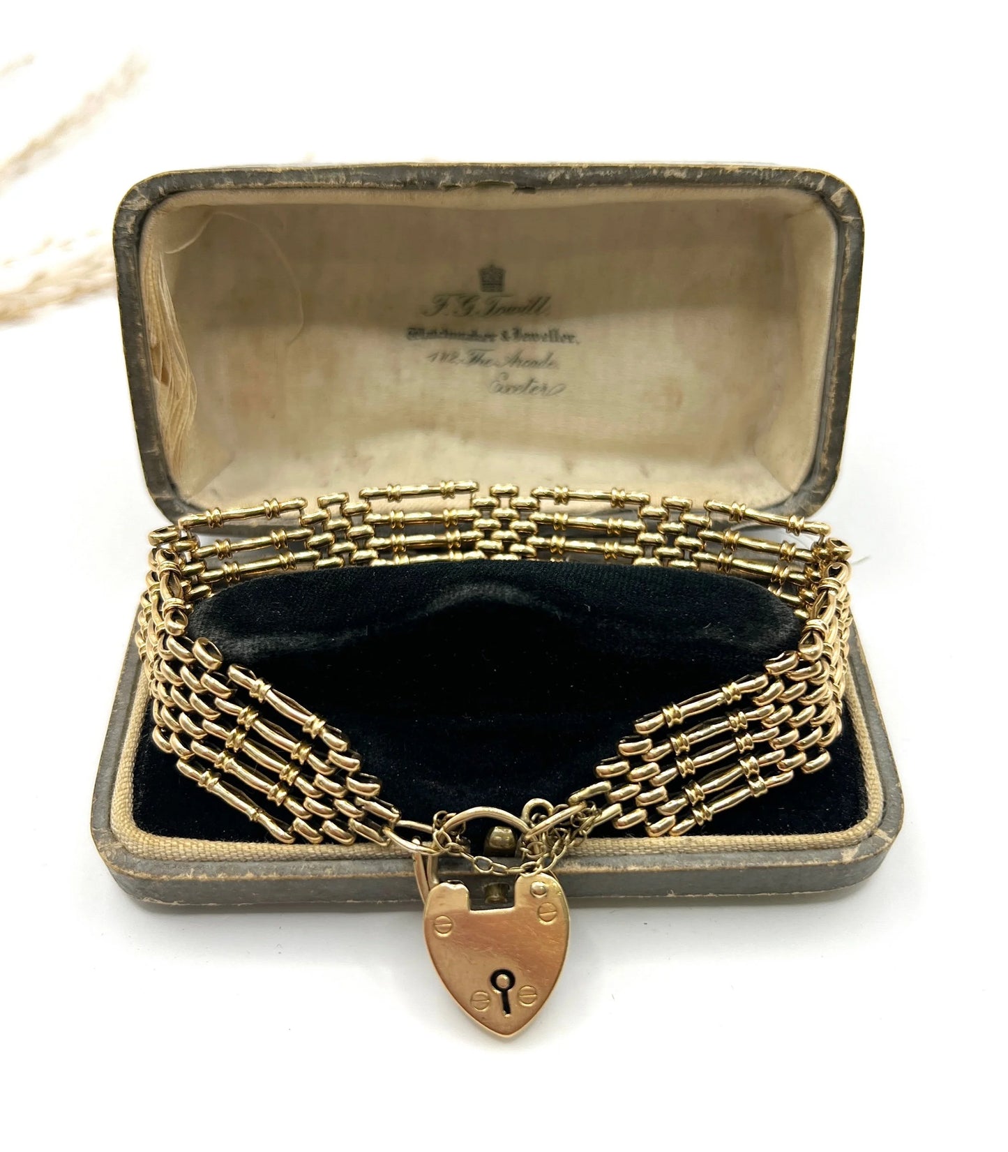 A yellow gold gate bracelet with heart shaped padlock clasp, in an antique bracelet box