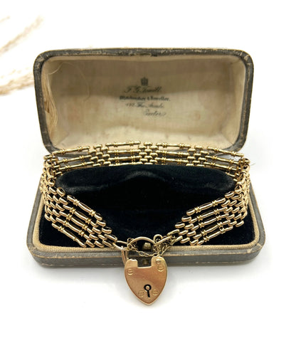A yellow gold gate bracelet with heart shaped padlock clasp, in an antique bracelet box