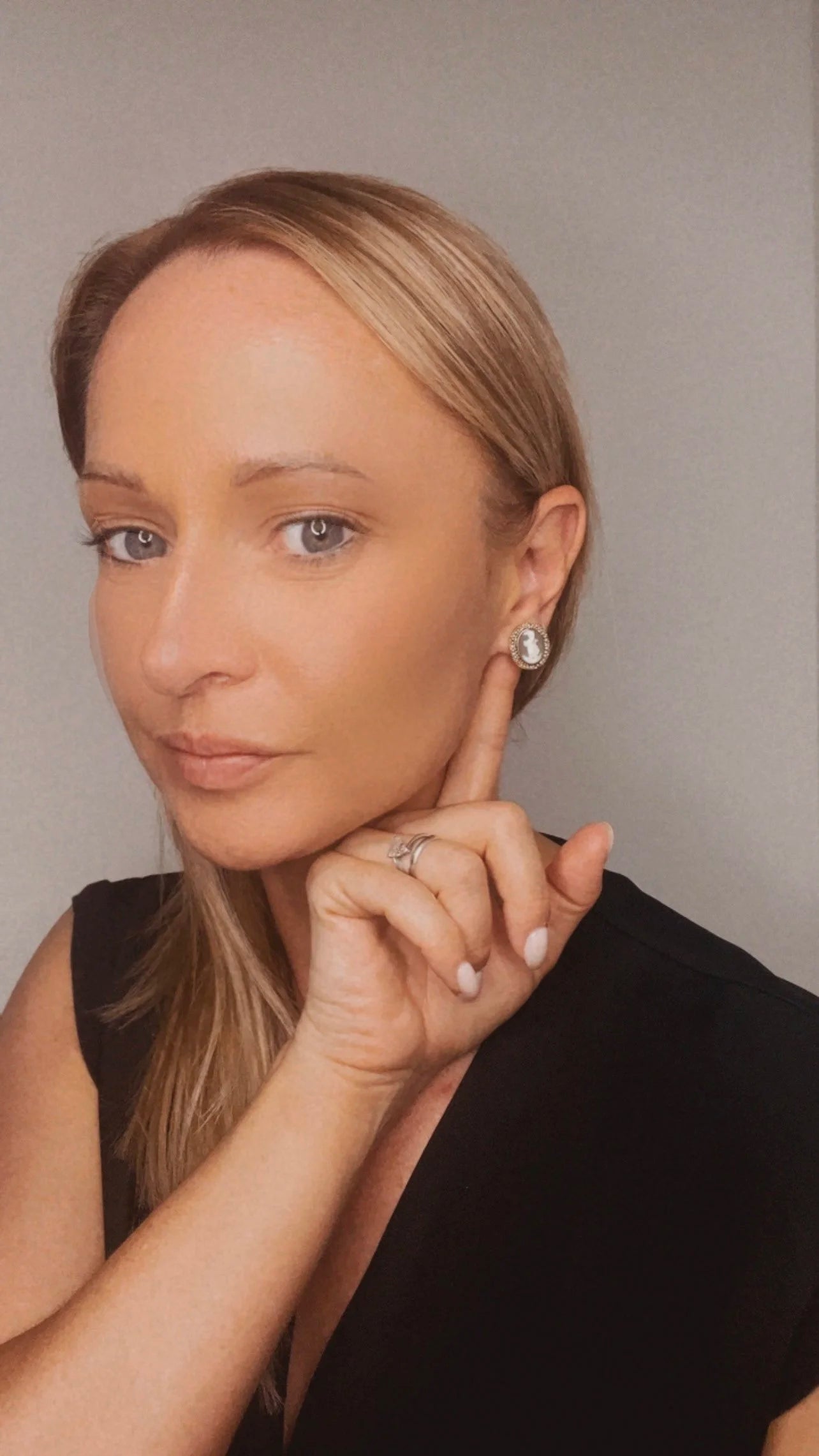 A yellow gold oval shell cameo earring, modelled in an ear