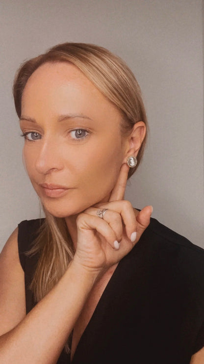 A yellow gold oval shell cameo earring, modelled in an ear