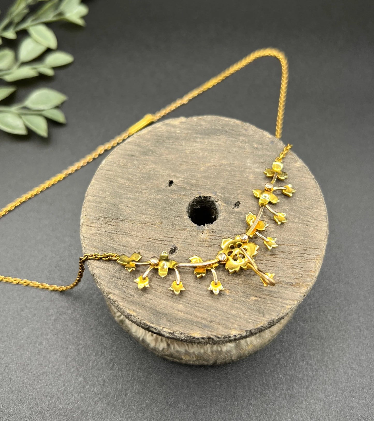 A yellow gold floral pendant necklace with seed pearls