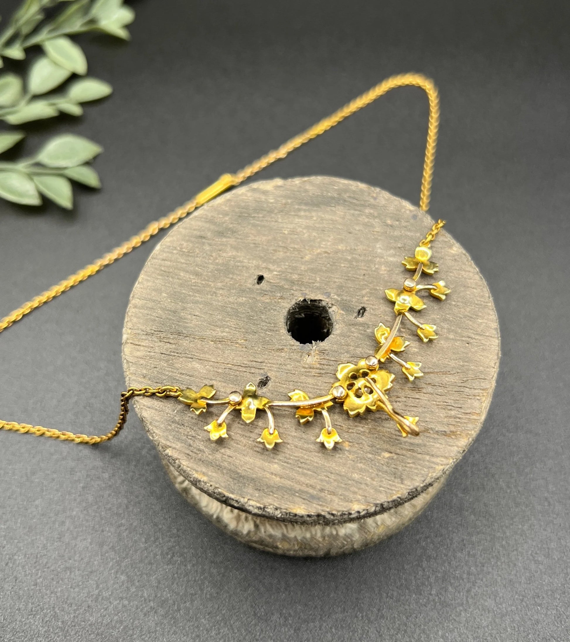A yellow gold floral pendant necklace with seed pearls